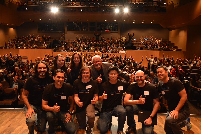 EvoNexus founders on stage in front of a packed Demo Day auditorium